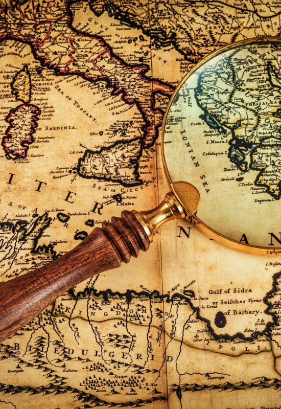 Old vintage magnifying glass on ancient map